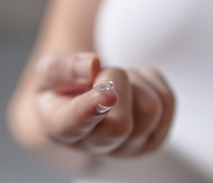 Young woman with contact lens on her finger. Contact Lens For Vision. Closeup Of Female holding Contact Lens. Beautiful Woman Putting Eye Lenses With Hands. Closeup picture of woman's finger holding contact lenses before putting on